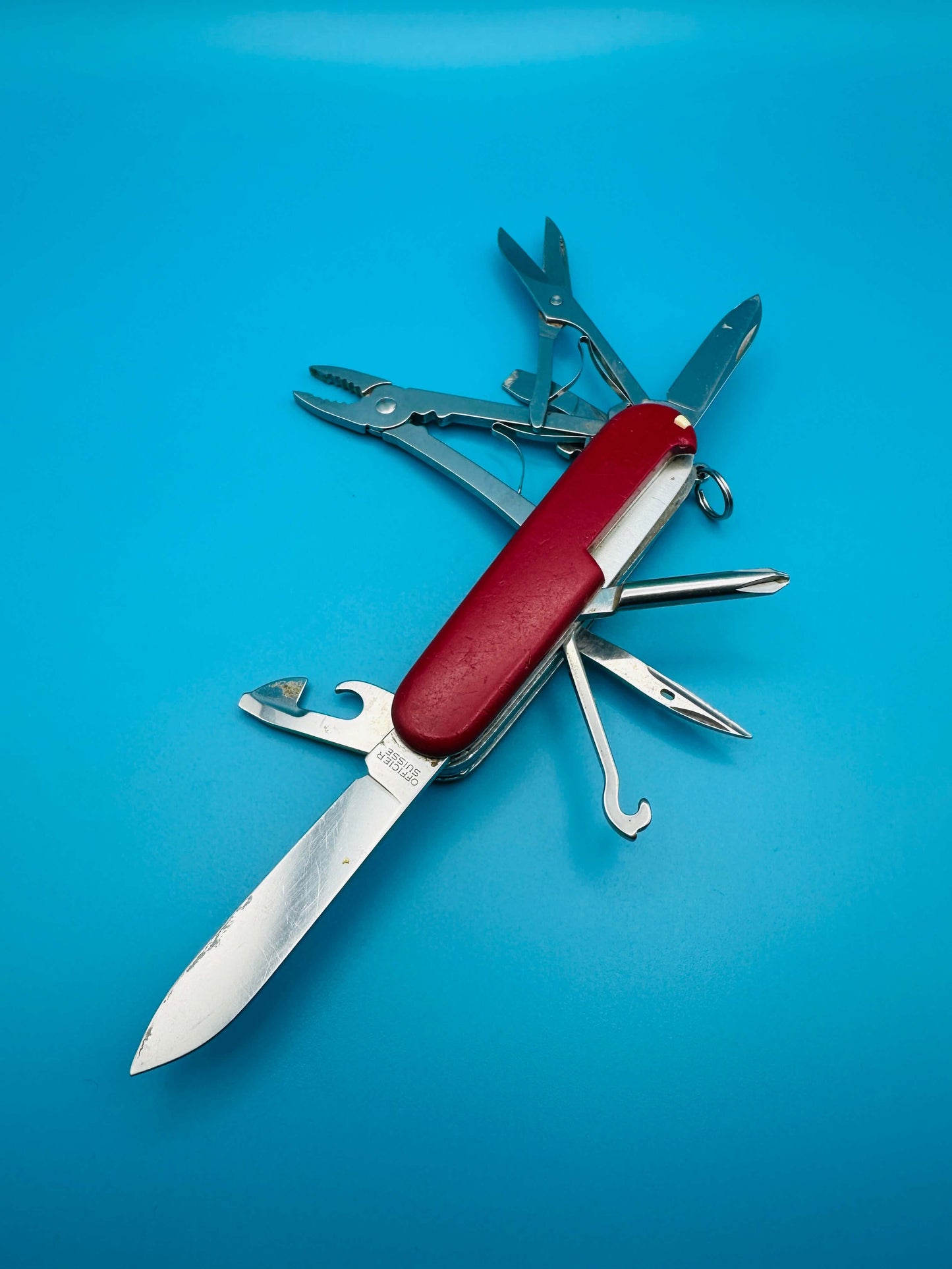 Victorinox Deluxe Tinker multitool opened with visible hook, knife, and pliers