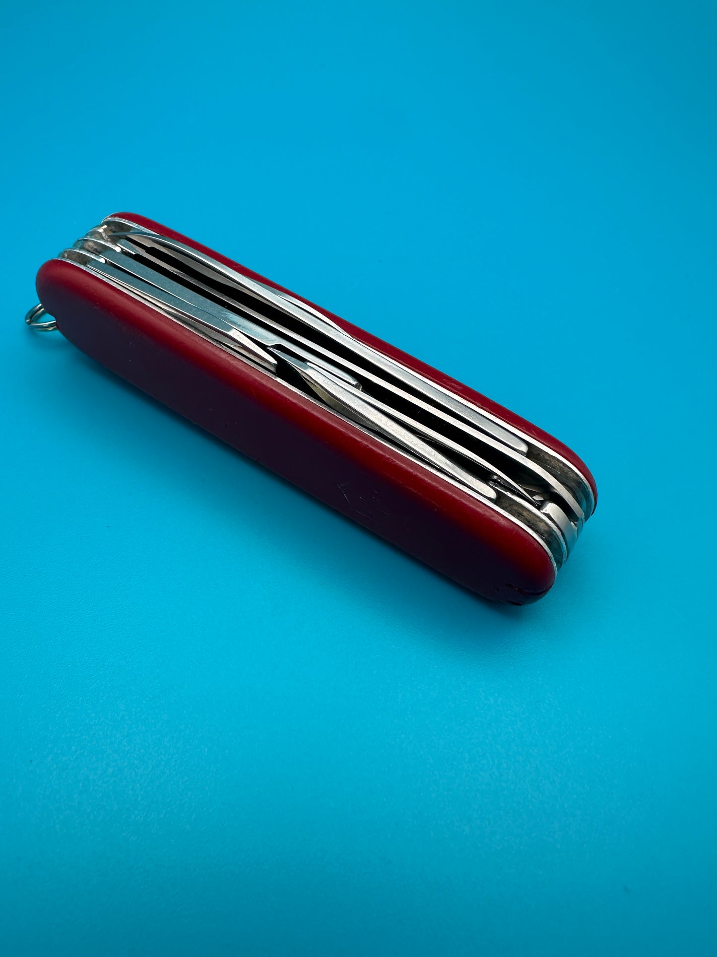 Folded Victorinox Huntsman Swiss Army knife resting on blue background