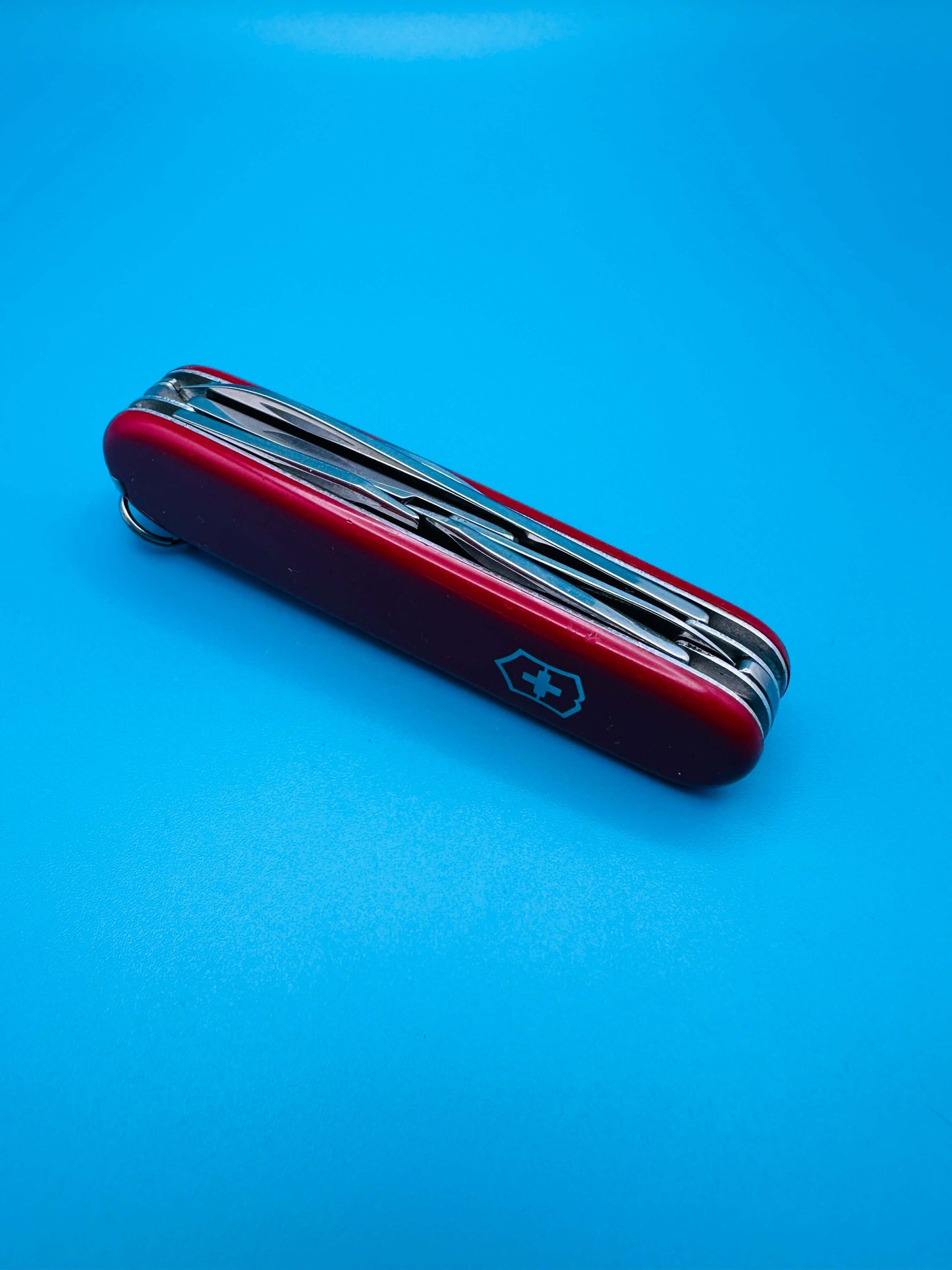 Closed Victorinox Climber Swiss Army knife, red casing with visible keyring and emblem on handle

