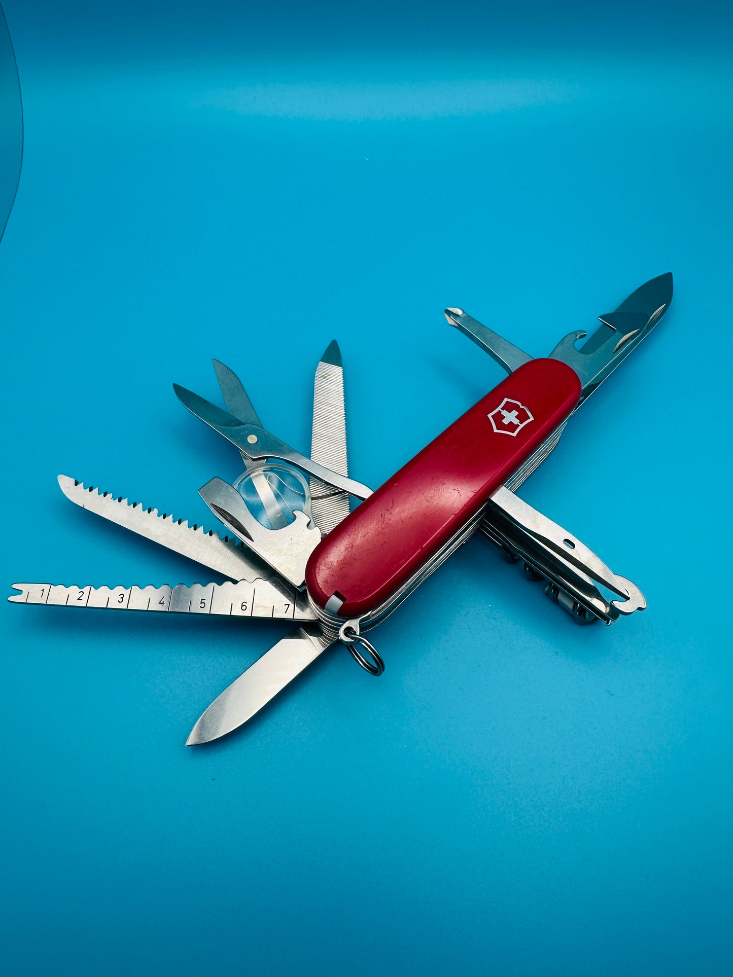 Victorinox Champion Plus showing scissors, saw, and corkscrew on red handle

