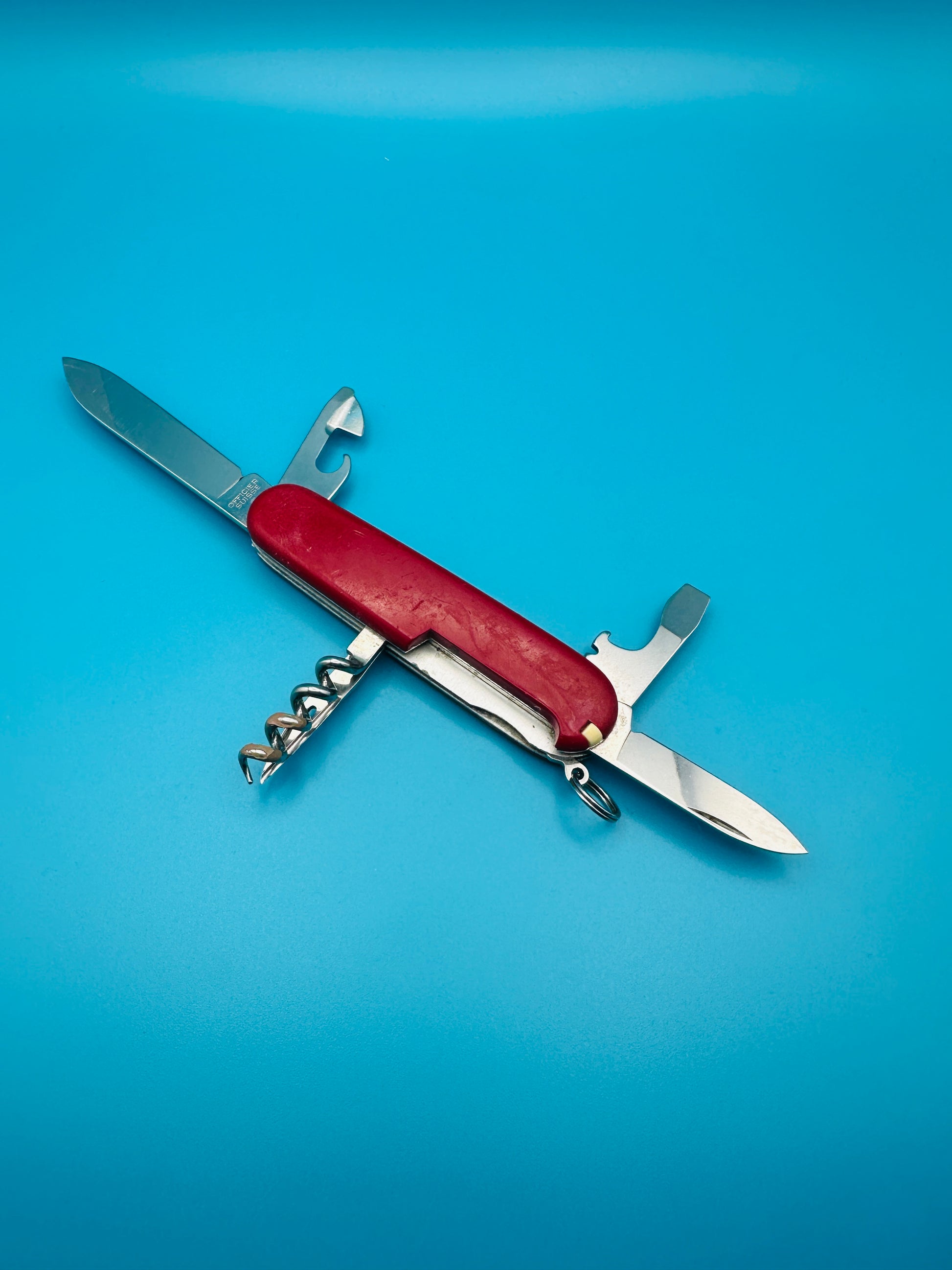 Open Spartan knife with partially extended tools on blue background