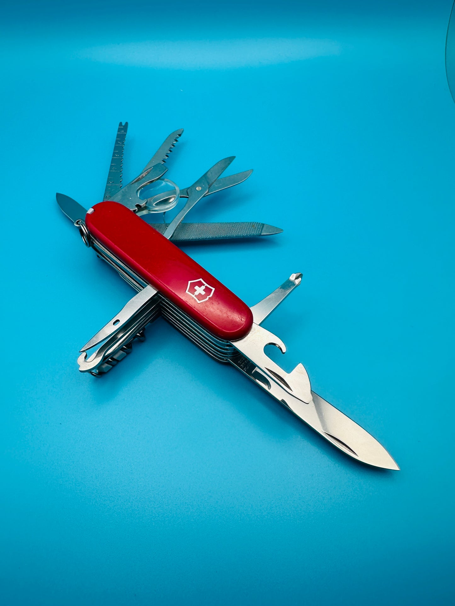 Victorinox Champion Plus Swiss Army knife with all tools extended on blue background
