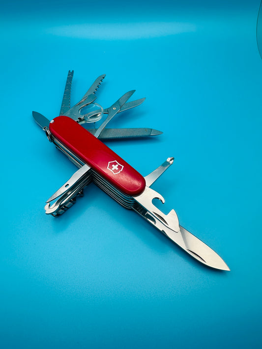 Victorinox Champion Plus Swiss Army knife with all tools extended on blue background