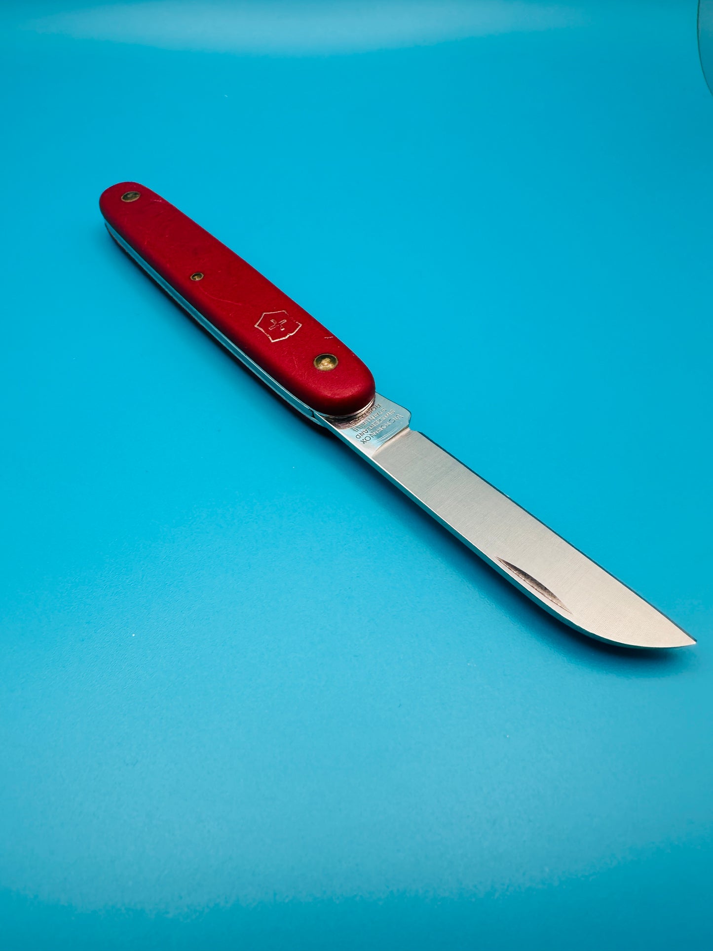 Used Victorinox Gardener knife with blade open and red matte handle
