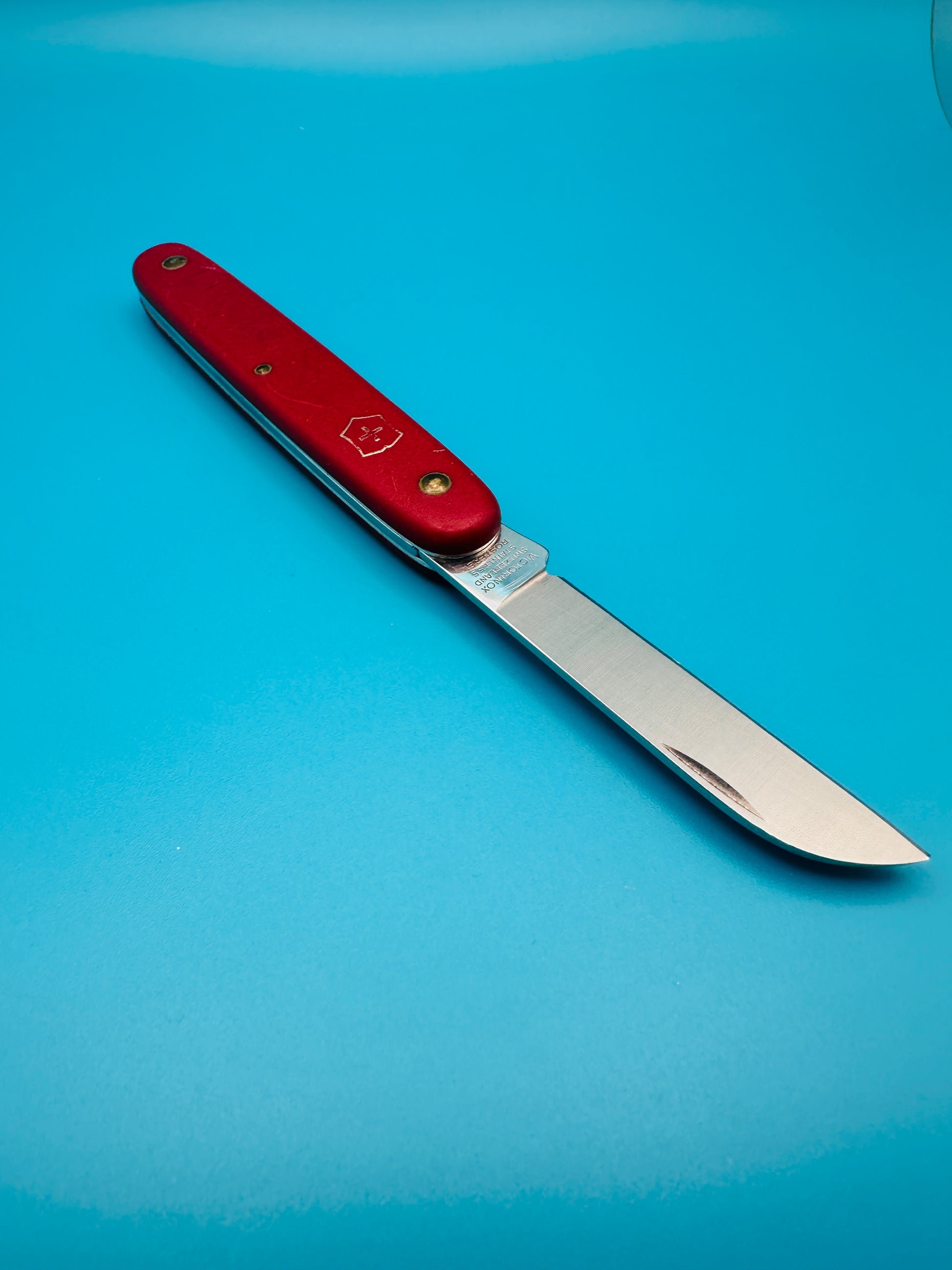 Used Victorinox Gardener knife with blade open and red matte handle